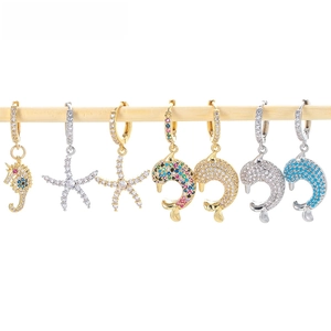Detailed macro view of gold and silver sea animal earrings encrusted with zircon crystals