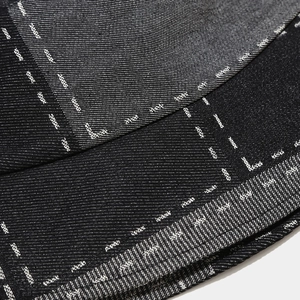 Makroaufnahme der Denim-Textur mit weißen Nähten und gesticktem Ader-Markendetail
