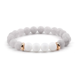 Detailed macro view of white marble beads with rose gold accents and matte white spheres