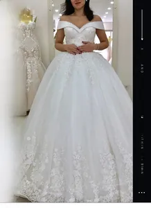 Détail de robe de mariée à épaules dénudées avec broderie florale et sequins brillants