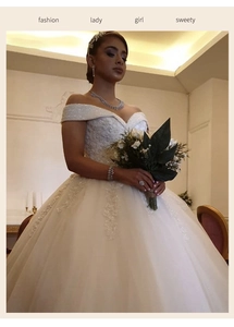 Détail d'une robe de mariée col bateau avec broderies de dentelle et paillettes brillantes
