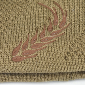Macro view of knit texture and wheat-shaped silicone print on men's winter hat