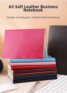 Multiple colors of A5 soft leather business notebooks stacked on an office desk