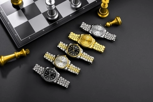 Detailed view of luxury steel band watches with calendar features on a dark surface
