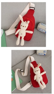 Detail of red canvas kids chest bag with cute plush bunny doll on a grey sofa