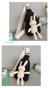 Detail of black canvas chest bag with a cute white long-eared bunny plush toy decoration