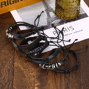 Multilayer leather bracelet set with woven ropes and metal cross charm on wood