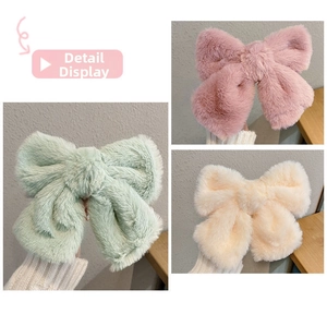 Detailed view of plush oversized bow hair clips in mint green, pink, and cream colors