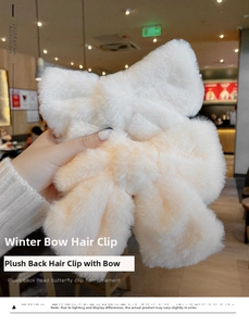 Detail of a large cream-colored plush bow hair clip with soft faux fur texture