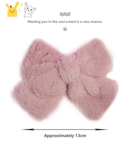 Detail view of a soft pink plush bow hair clip with a 13cm diameter measurement