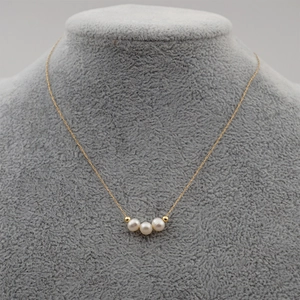 French style thin titanium steel necklace with freshwater pearls on a gray mannequin