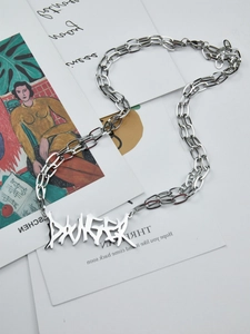 Close-up of stainless steel double chain necklace featuring silver DANGER letter pendant