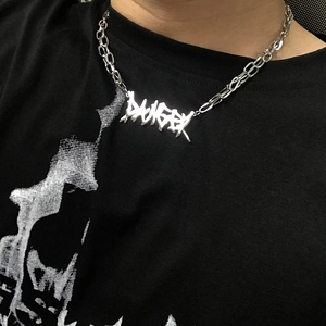 Detail of silver double-layered chain necklace featuring a bold DANGER letter pendant
