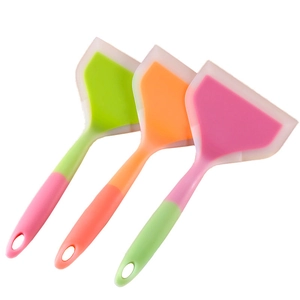 Trois spatules en silicone colorées pour tamagoyaki et steak sur fond blanc pur