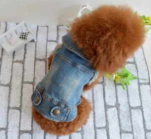 Detail of distressed blue denim dog vest with fleece lining and brass snap buttons
