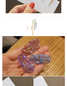 Detail of cute cat-shaped acetate hair clips with glitter finish and gold feline motifs