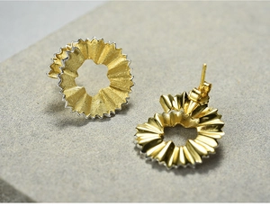 Macro view of creative S925 silver pencil shaving earrings in gold and silver finish