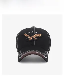 Detailed close-up of eagle embroidery and white contrast stitching on black cotton baseball cap