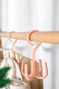 Detailed view of pink rotatable closet hook organizer with four hooks for bags and scarves