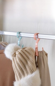 Rotating four-prong plastic hanger hooks for scarves, belts, and bags in a closet scenario