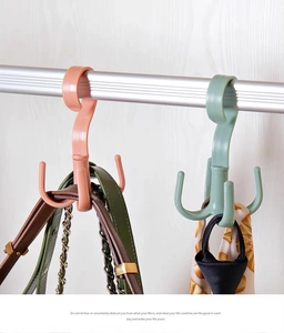 Rotating 4-prong plastic organizer hook holding belts and scarves in a closet