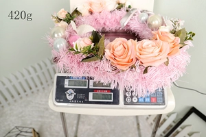 Detailed view of pink rose wreath featuring silver baubles and green leaves weighing 420g