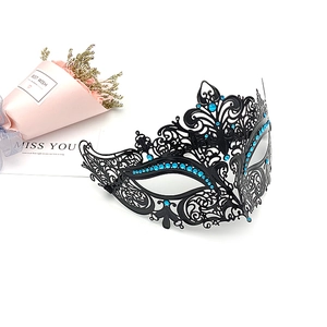 Detailed 45-degree angle of black metal filigree mask with sparkling blue rhinestones