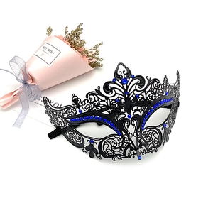 Detailed view of black filigree metal mask with sparkling blue rhinestones for masquerade