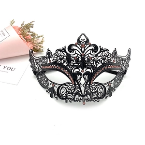 Detailed close-up of a black metal masquerade mask with pink rhinestones and laser-cut patterns