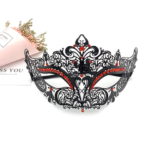 Detail of laser-cut black metal masquerade mask with sparkling red rhinestones