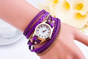 Detail of purple braided rope and gold metal chains on wrap-around bracelet watch