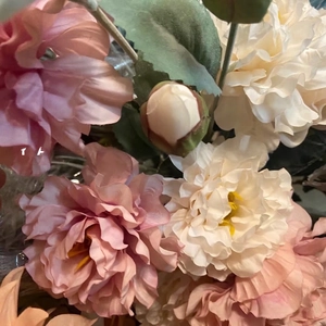 Close-up of pink and cream faux peonies featuring layered silk petals and realistic buds