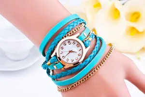 Detail of vintage turquoise braided wrap watch with gold chains on woman's wrist
