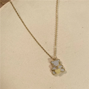 Close-up of golden bear pendant with white mother of pearl inlay and love heart engraving