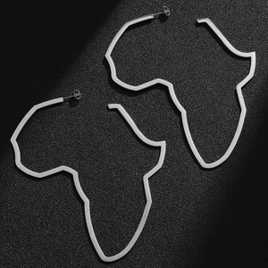 Macro view of silver Africa map silhouette earrings on textured black background