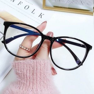 Classic large black round frame glasses with blue light blocking lenses held by hand