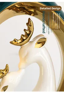 Dettaglio di sculture di cervi in ceramica bianca con corna e orecchie dorate