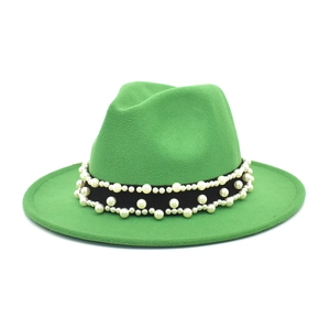 Close-up of green wool fedora hat featuring black ribbon with elegant pearl decorations