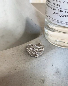 Detailed view of 925 silver irregular layered ring on a grey minimalist concrete surface