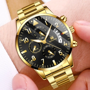 Detail of gold stainless steel watch with black dial and date window on a male wrist