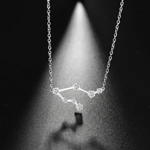 Pendentif Balance en argent avec strass brillants sur fond noir, style minimaliste élégant