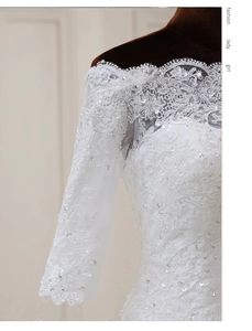 Détail de la robe de mariée blanche aux épaules dénudées avec broderie et paillettes