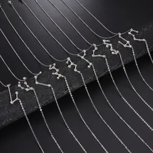 Colliers zodiaque en argent avec diamants étincelants sur des supports cylindriques noirs