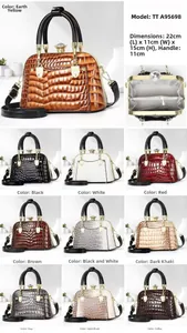 Detail view of crocodile pattern handbag with gem buckle and organized internal compartments