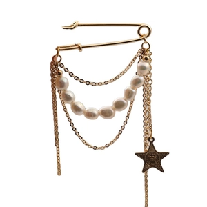 Golden safety pin brooch with freshwater pearls and tassel chains featuring star charm