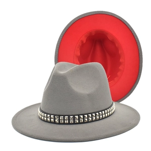 Detail of grey wool fedora hat featuring a red brim interior and silver studded leather band