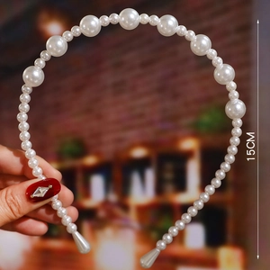 Detail shot of white pearl headband featuring gradient sizes and 15cm width measurement