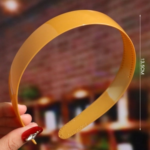 Detail view of orange glossy plastic headband with non-slip teeth and 13.5cm width
