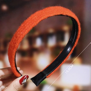 Detail view of orange plush wavy headband with internal teeth showing 15.5cm size