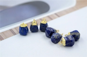 Macro shot of faceted blue lapis lazuli pendants with gold plated top loops
